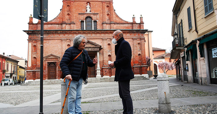 El Alcalde de Codogno, epicentro del brote de coronavirus en Italia, Francesco Passerini (der), conversa con un hombre el 12 de marzo del 2020. La pequeña ciudad lombarda ha tenido un comportamiento ejemplar y reducido la propagación del virus. Foto: Antonio Calanni, AP