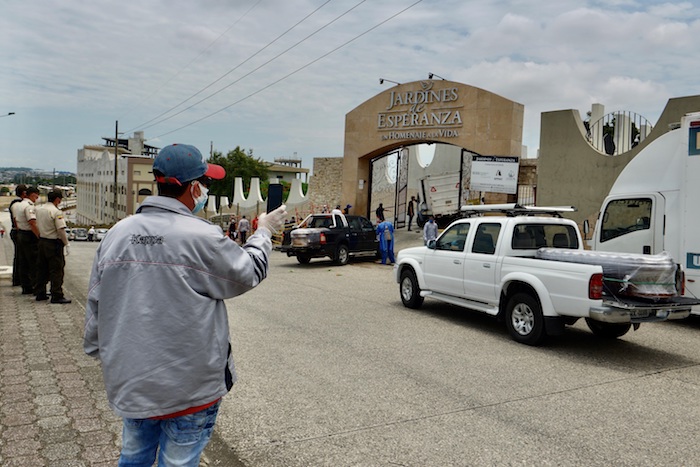 Vista este miércoles de dos vehículos que transportan los féretros de dos fallecidos por COVID-19, a su llegada a un cementerio de Guayaquil (Ecuador). Foto: Marcos Pin, EFE