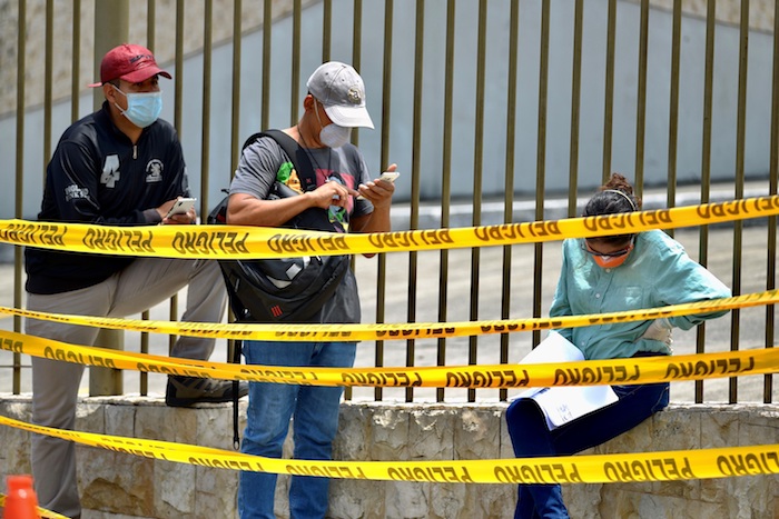 Familiares con tapabocas esperan este miércoles la llegada de los féretros con sus seres queridos a un cementerio de Guayaquil (Ecuador). Foto: Marcos Pin, EFE