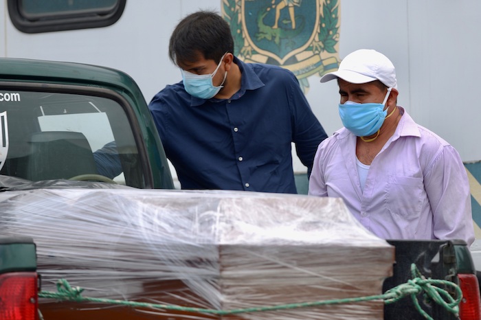 Familiares observan este miércoles el féretro de su ser querido fallecido a causa del coronavirus COVID-19, a su llegada a un cementerio de Guayaquil (Ecuador). Foto: Marcos Pin, EFE