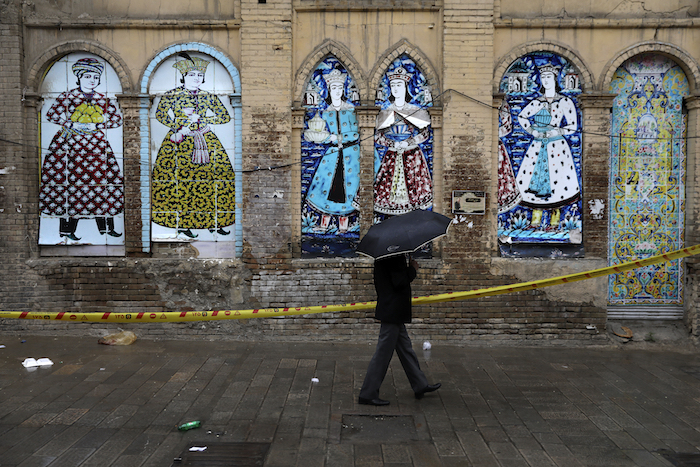 Un Hombre Se Resguarda De La Lluvia Bajo Un Paraguas Mientras Pasa Por Delante De Un Edificio Decorado Con Una Réplica De Pinturas Antiguas Iraníes En Una Calle Casi Vacía De Un Distrito Comercial En El Centro De Teherán Irán El De Marzo De Foto Vahid Salemi Ap