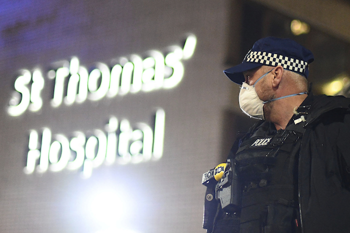 Un agente de policía ante el hospital de St Thomas en el centro de Londres, después de que el primer ministro británico, Boris Johnson, fuera trasladado a cuidados intensivos al empeorar sus síntomas por coronavirus, el lunes 6 de abril de 2020. Foto: Victoria Jones/PA vía AP