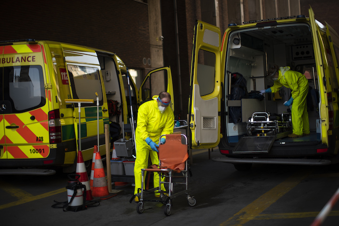 Bomberos con equipo de protección desinfectan una ambulancia tras su uso para trasladar a un paciente de coronavirus, en un cuartel de bomberos en Bruselas, el jueves 9 de abril de 2020. 