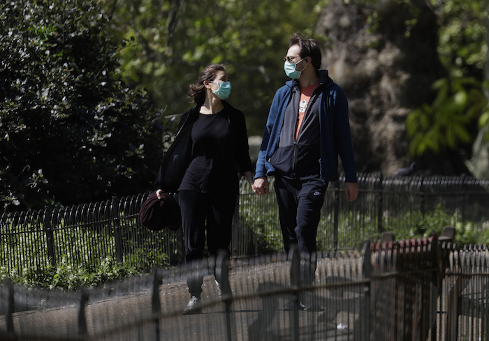 Unas personas con mascarillas caminan por el parque St. James en Londres, mientras el país sigue en confinamiento para ayudar a frenar la propagación del nuevo coronavirus, el domingo 19 de abril de 2020.