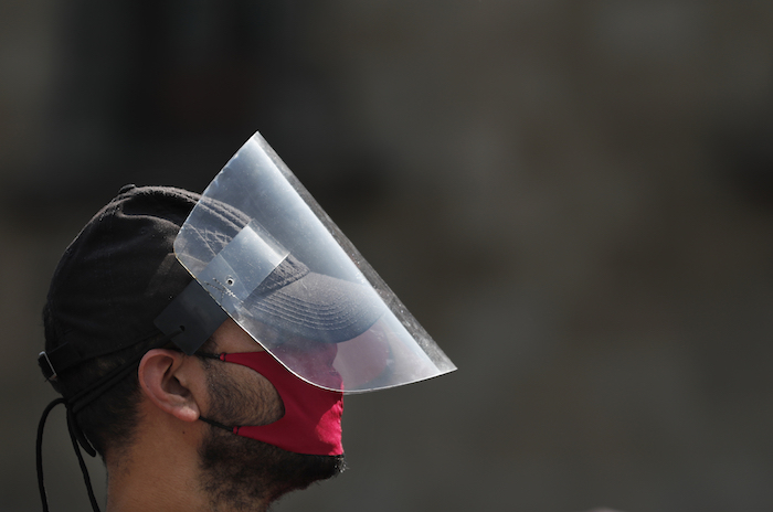 Un transeúnte que porta una mascarilla y un protector camina por la plaza principal de la capital mexicana, conocida como Zócalo, el martes 21 de abril de 2020, en la Ciudad de México. 