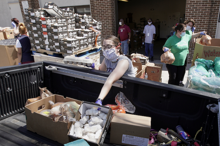 Trabajadores del banco de alimentos Together Omaha cargan suministros alimentarios en un vehículo en Omaha, Nebraska, el jueves, 23 de abril del 2020.