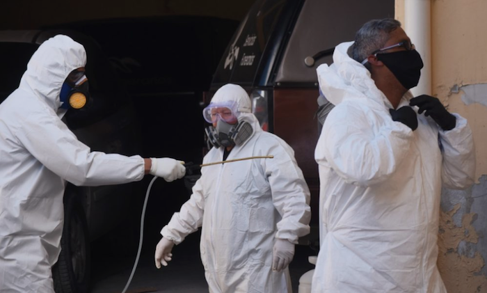 Entre los mismos compañeros se sanitizan los trajes de protección. Foto: Rey R. Jauregui, La Verdad de Juárez