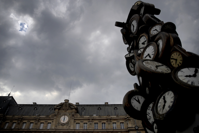 El reloj de la estación Saint Lazare, a la izquierda, y la escultura "L'Heure de Tous" ("La hora de todos") del artista francés Arman, fotografiados en París a las 18:00 del viernes 24 de abril de 2020.