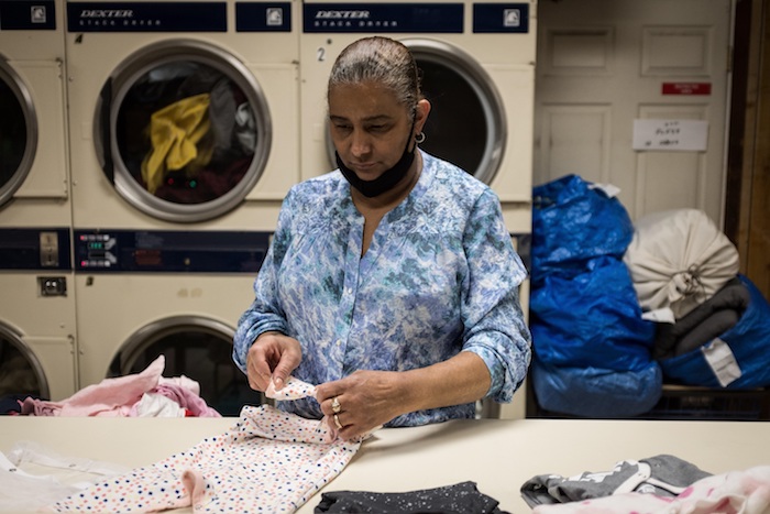 Nancy Cruz, de 55 años y originaria de República Dominicana, fue registrada al doblar ropa en 'Graham Laundromat', el negocio familiar en el que trabaja durante la actual pandemia por la COVID-19, en Brooklyn (Nueva York, EU). 