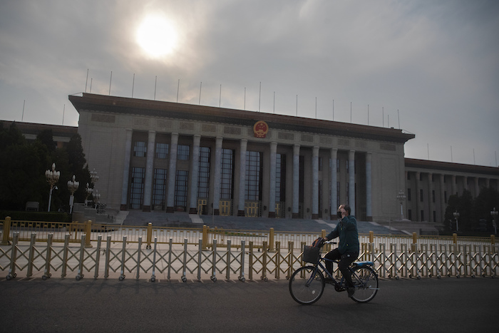 Un Hombre Con Una Máscara Protectora Pasa En Su Bicicleta Junto Al Gran Salón Del Pueblo El Edificio De La Legislatura China En Beijing El Miércoles De Abril Del