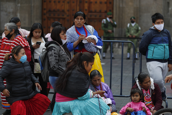 Miembros de comunidades indígenas usan mascarillas frente al Palacio Nacional mientras exigen apoyo del Gobierno el lunes 11 de mayo de 2020, dado que las medidas de distanciamiento social les impiden vender sus artesanías en las calles de la Ciudad de México. 