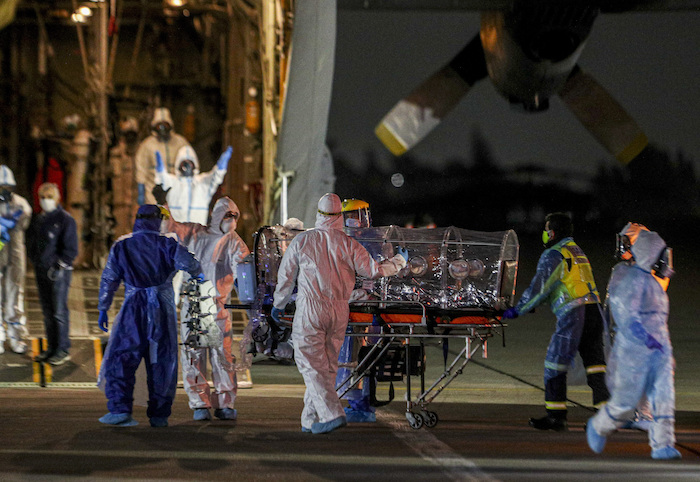 Trabajadores de salud trasladan a un paciente enfermo de COVID-19 desde una base chilena de la fuerza aérea a la ciudad de Concepción el martes 19 de mayo de 2020, con el fin de liberar espacio en las unidades de cuidados intensivos de la capital, en Santiago, Chile.