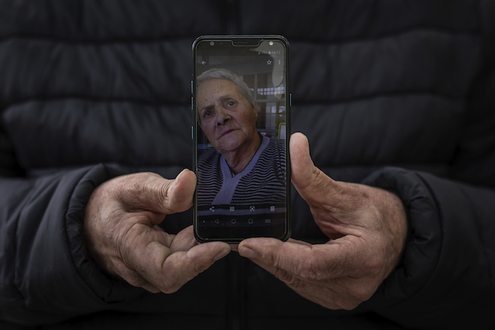 En esta imagen, tomada el 13 de mayo de 2020, Andrés Campos muestra una fotografía de su suegra, Carmen López, de 84 años, en Madrid, España. 