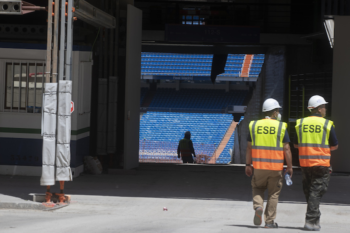 Un par de trabajadores se dirige al estadio Santiago Bernabéu, sede del club Real Madrid, el lunes 25 de mayo de 2020, en Madrid, España. 