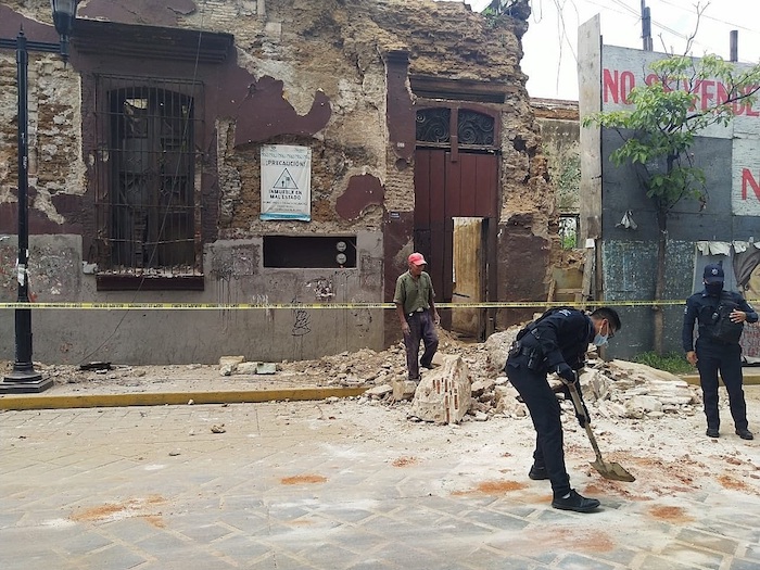 Policías y elementos de Protección Civil levantan parte de una barda derrumbada en la ciudad de Oaxaca (México).