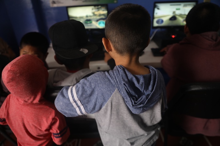 Un grupo de menores que permanecen es una casa de acogida observando computadoras el pasado 13 de mayo, en Ciudad de México (México). 