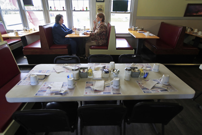 En esta fotografía del 18 de mayo de 2020 unos clientes comen adentro del restaurante Hot Spot Diner, en Wiscasset, Maine. 