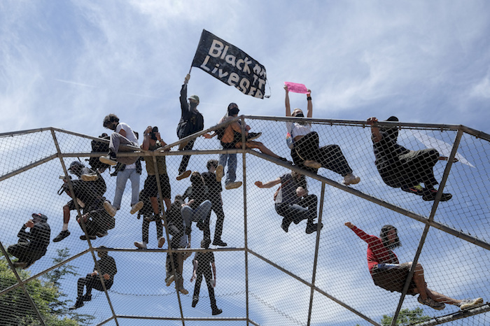 Gente sobre una estructura de bateo durante una protesta por la muerte de George Floyd en Los Ángeles, el sábado 30 de mayo de 2020. 