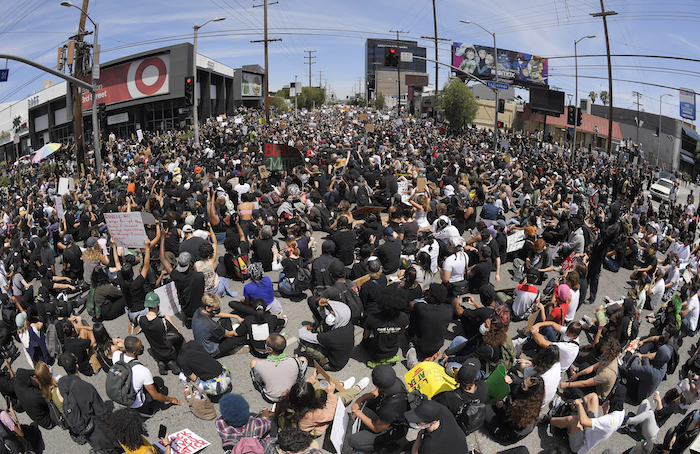 En esta imagen tomada con un gran angular, manifestantes sentados en un cruce durante una protesta por la muerte de George Floyd, un hombre afroamericano que murió tras ser detenido por la policía en Minneapolis, el sábado 30 de mayo de 2020 en Los Ángeles. 