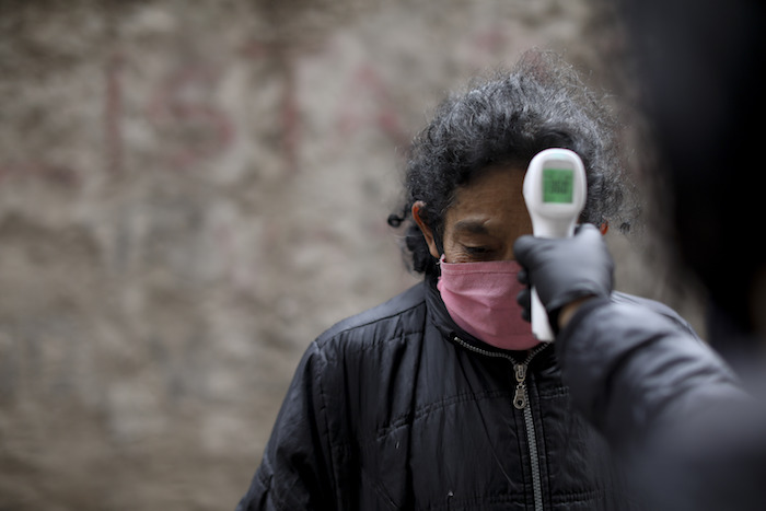 Un voluntario mide la temperatura de residentes dentro del barrio marginal de Fraga durante un confinamiento ordenado por el Gobierno para frenar la propagación del nuevo coronavirus, en Buenos Aires, Argentina, el sábado 6 de junio de 2020. 