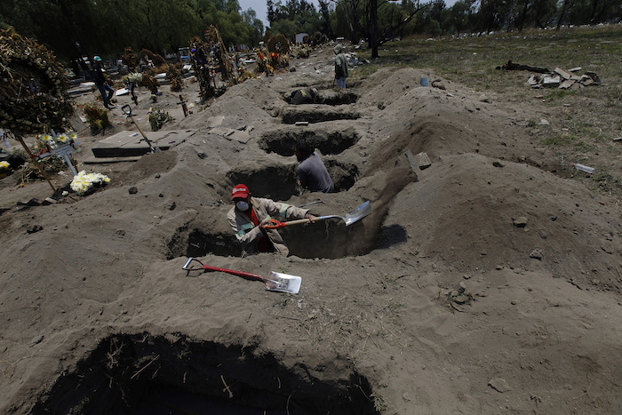 Melvin Sanaurio, frente, cava una tumba en el cementerio San Lorenzo Tezonco en Ciudad de México el martes 2 de junio de 2020 durante la pandemia del nuevo coronavirus. "En cada una de ellas nos demoramos más de una hora", dijo Sanuario. 