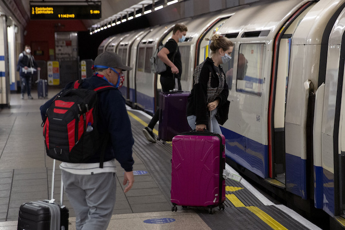 Personas Con Mascarillas Que Aterrizaron En El Aeropuerto De Heathrow Suben a Un Tren Subterráneo Con Destino a Londres En Las Terminales Del Metro Heathrow Y En Londres