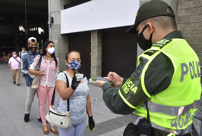 Un policía de Medellín usa un nuevo software para escanear documentos de identidad y determinar si una persona está autorizada a salir de su casa ese día en plena pandemia del coronavirus. Foto del 8 de junio del 2020. 