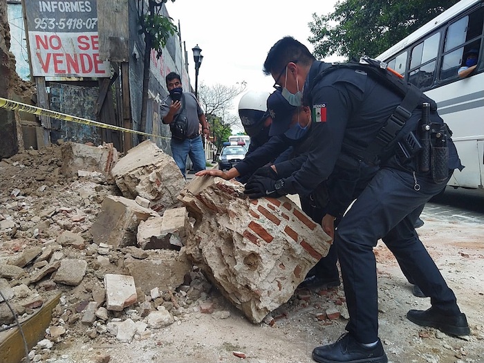 Policías y elementos de Protección Civil levantan parte de una barda derrumbada en la ciudad de Oaxaca (México). 