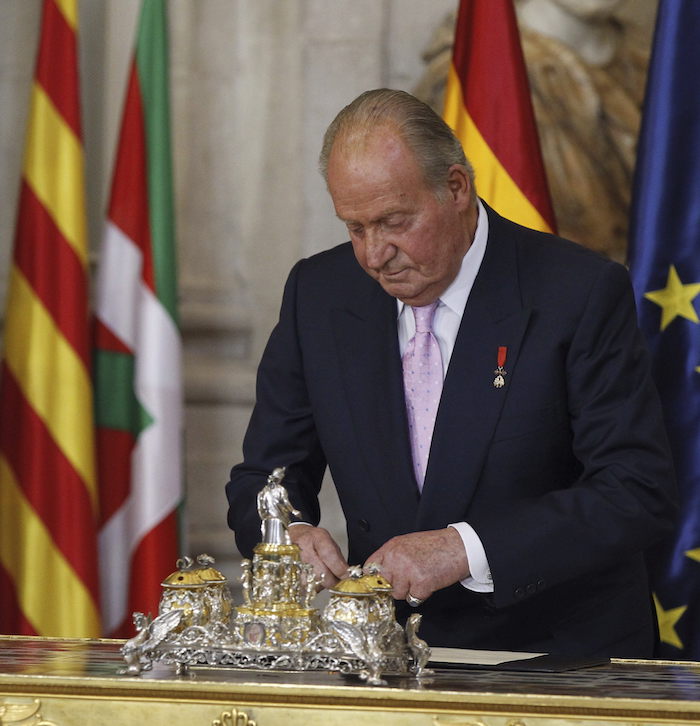 El rey Juan Carlos durante la firma de la ley orgánica que hizo efectiva su abdicación, en una solemne ceremonia celebrada en el Salón de Columnas del Palacio Real. 