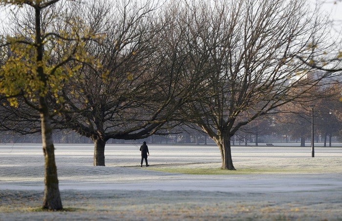 Un hombre camina por las calles cubiertas de escarcha de un campo de golf en el centro de Christchurch, Nueva Zelanda.