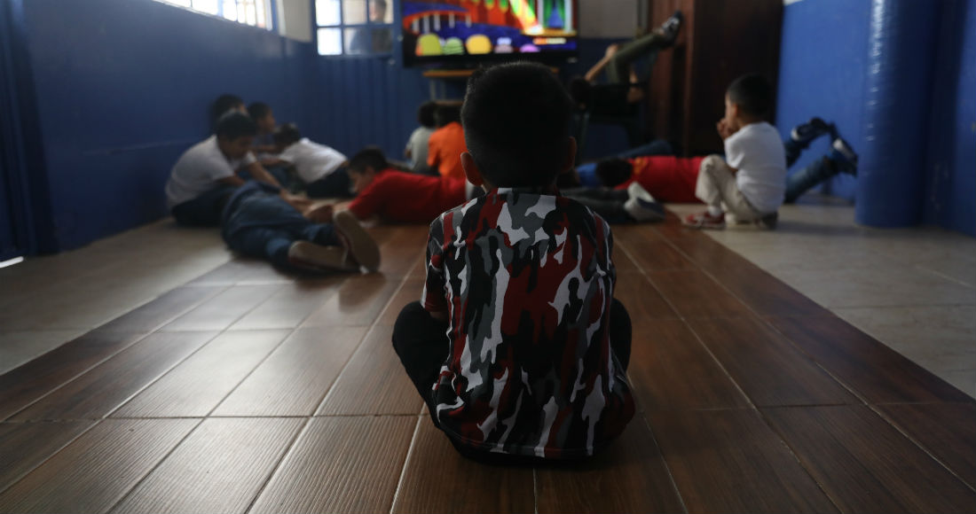 Un grupo de menores que permanecen es una casa de acogida observando el televisor el pasado 13 de mayo, en Ciudad de México (México).