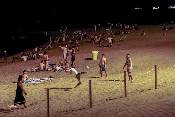 Varios jóvenes se divierten en una playa de Barcelona, anoche, tras el cierre de discotecas decretado por las autoridades catalanas para evitar la propagación del coronavirus. 