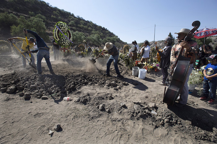 En esta imagen, tomada el 15 de junio de 2020, familiares entierran a Mauricio Ortega, de 67 años, mientras una banda toca en el cementerio municipal Valle de Chalco, a las afueras de la Ciudad de México. Según la familia, Ortega murió por complicaciones relacionadas con la COVID-19. 