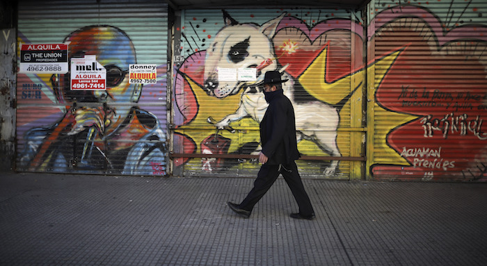 Un hombre pasea por una zona comercial con tiendas cerradas durante una cuarentena decretada por el Gobierno para frenar la propagación del nuevo coronavirus, en Buenos Aires, Argentina, el 26 de junio de 2020. 