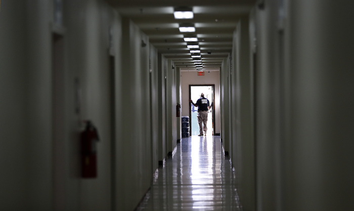 En esta imagen del martes 9 de julio de 2019, personal recorre un dormitorio en el más reciente centro de detención para niños migrantes del Gobierno de Estados Unidos en Carrizo Springs, Texas. 