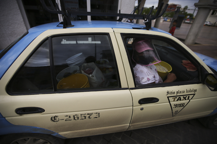 Una Vendedora De Comida Que Utiliza Una Pantalla Facial Para Protegerse Durante La Pandemia De La Covid Usa Un Taxi Para Trasladar Su Mercancía En Acatlán De Osorio Una Localidad Mexicana Que Vive Con Las Remesas De Los Residentes Emigrados El De Junio De El Banco Mundial Y La Onu Estiman Que Las Remesas Caerán Este Año Cerca De Un En América Latina Aunque México Parece Ir a Otro Ritmo