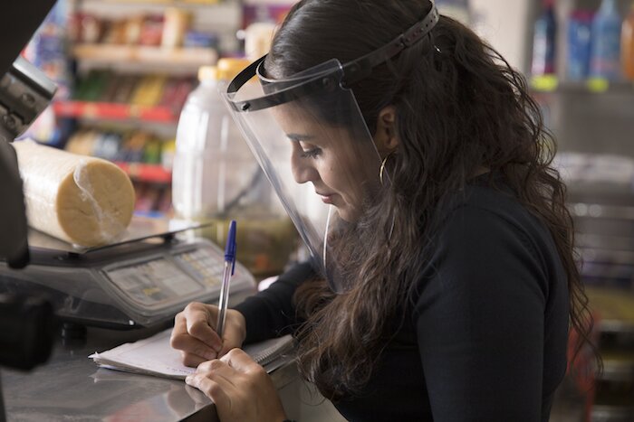 Una mujer atiende una tiendita.