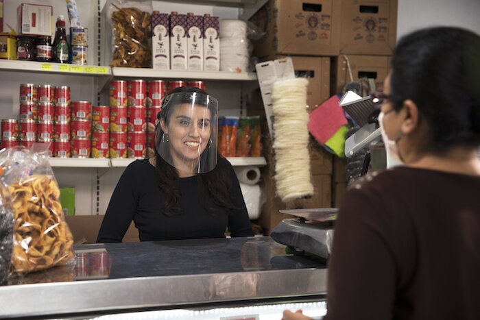 Una mujer atiene una tiendita.