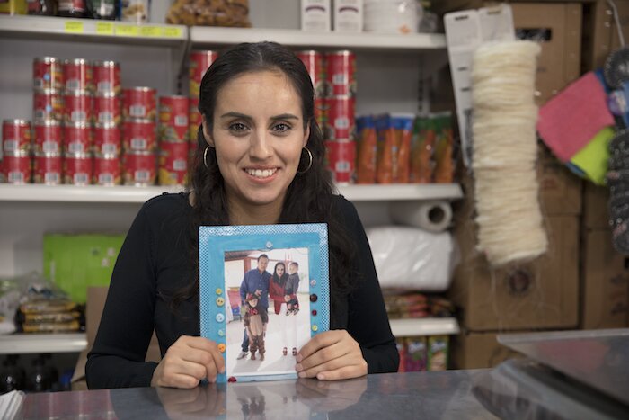 Una mujer atiende una tiendita.