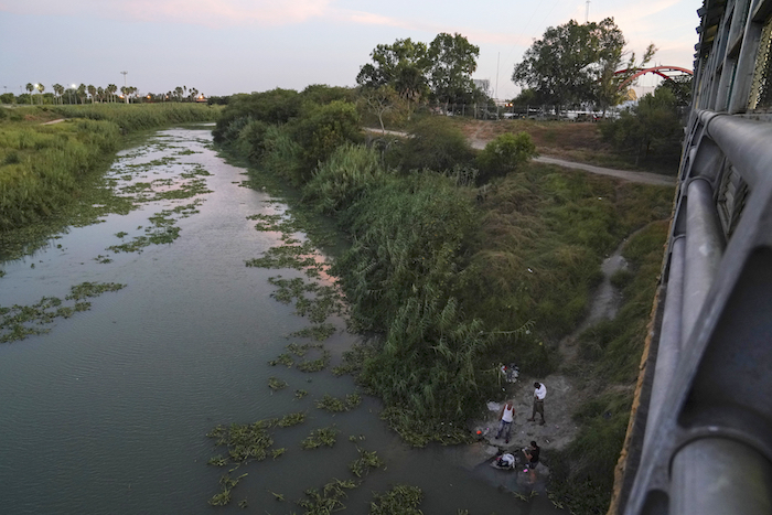 En esta fotografía del 30 de agosto de 2019, unos solicitantes de asilo lavan su ropa en el río Bravo, cerca del puente internacional Gateway, en Matamoros, México. 