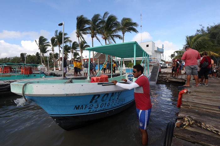 Pescadores y prestadores de servicios del centro de recreo trabajan en el retiro de embarcaciones que podrían colapsar con la llegada del huracán "Delta" en Cancún, estado de Quintana Roo (México). 