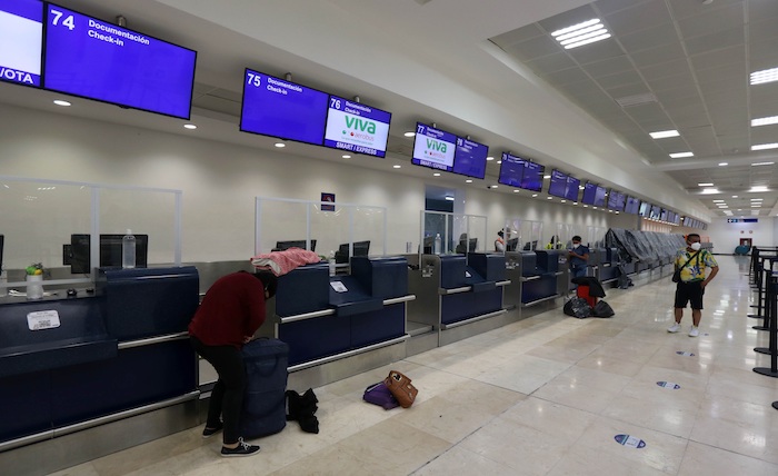 Pasajeros intentan permanecer en las instalaciones del Aeropuerto Internacional de la ciudad de Cancún (México), ante la llegada del huracán "Delta" al estado de Quintana Roo. 