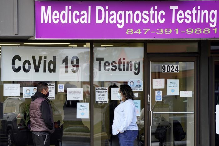 Exam Corp Lab, derecha, habla con un paciente que espera el test de COVID-19 en Niles, Illinois. Estados Unidos alcanzó un nuevo récord de 83.000 contagios en un solo día, se informó el sábado 24 de octubre de 2020.