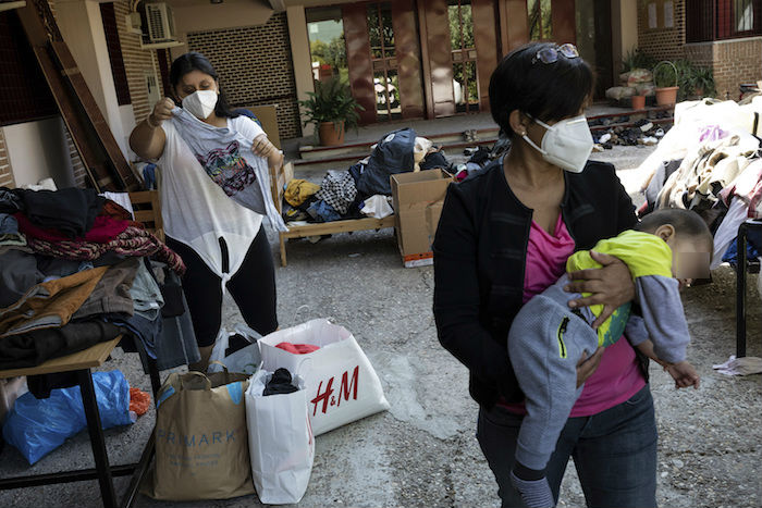 Vecinos en el vecindario de Vallecas, en el sur de Madrid, recogen ropa de un programa de donaciones en una parroquia católica en Madrid, España, el jueves 1 de octubre de 2020.