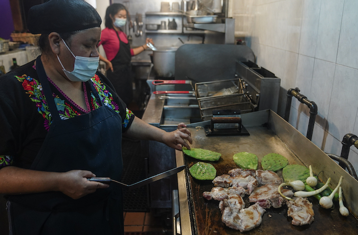 Natalia Méndez prepara una comida con chuletas de cerdo, jalapeños y plantas de cactus en la cocina de La Morada, un restaurante mexicano galardonado del que es copropietaria con su familia en el sur del Bronx, el miércoles 28 de octubre de 2020, en Nueva York. 