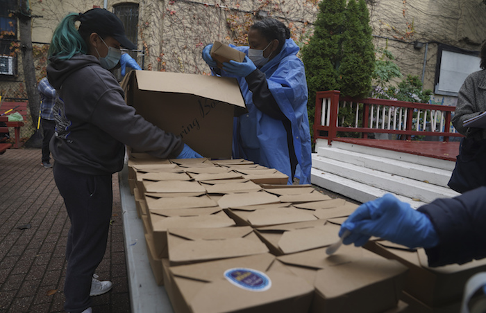 Voluntarios descargan comidas en caja preparadas en el restaurante La Morada del sur del Bronx, el miércoles 28 de octubre de 2020, en Nueva York. 