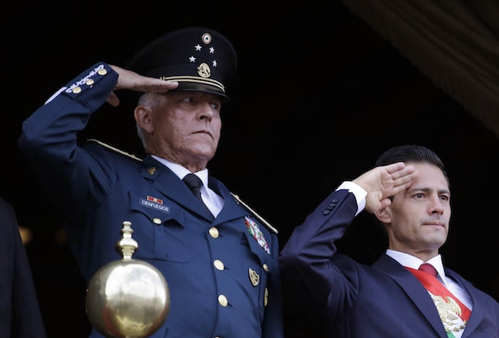 En esta imagen del 16 de septiembre de 2016, el entonces Secretario de Defensa, General Salvador Cienfuegos, a la izquierda, acompaña al Presidente de México Enrique Peña Nieto, durante el desfile militar por el Día de la Independencia en la plaza principal de la Ciudad de México.