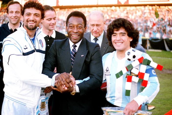 En esta foto de archivo del 10 de junio de 1987, la leyenda del futbol brasileño Pelé, en el centro, toma de la mano al capitán italiano Alessandro Altobelli, a la izquierda, y al capitán argentino Diego Maradona, luego de recibir la medalla de honor de la FIFA antes del inicio de un partido entre Argentina e Italia en Zurich, Suiza. 