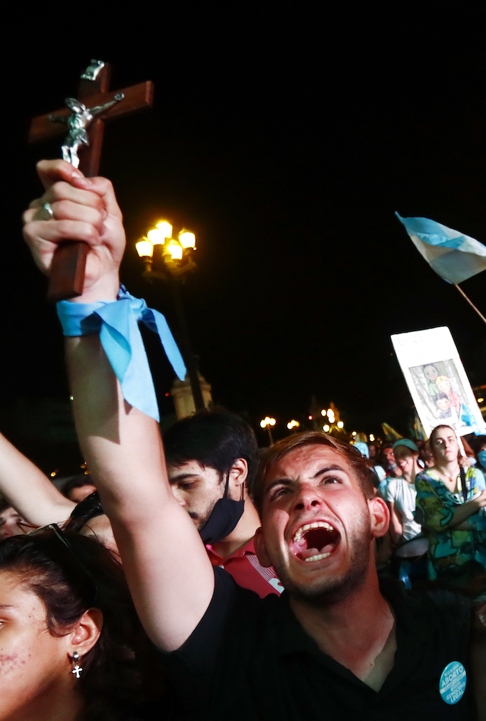 Un manifestante en contra del aborto sostiene un crucifijo mientras senadores debaten la legalización de la interrupción del embarazo en Buenos Aires, Argentina, el miércoles 30 de diciembre de 2020. 