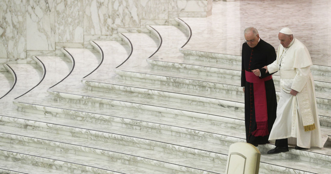 En esta imagen de archivo, tomada el 21 de diciembre de 2020, el Papa Francisco recibe ayuda de monseñor Leoardo Sapienza para bajar las escaleras durante un saludo de Navidad con empleados del Vaticano, en el salón Pablo VI, en el Vaticano.